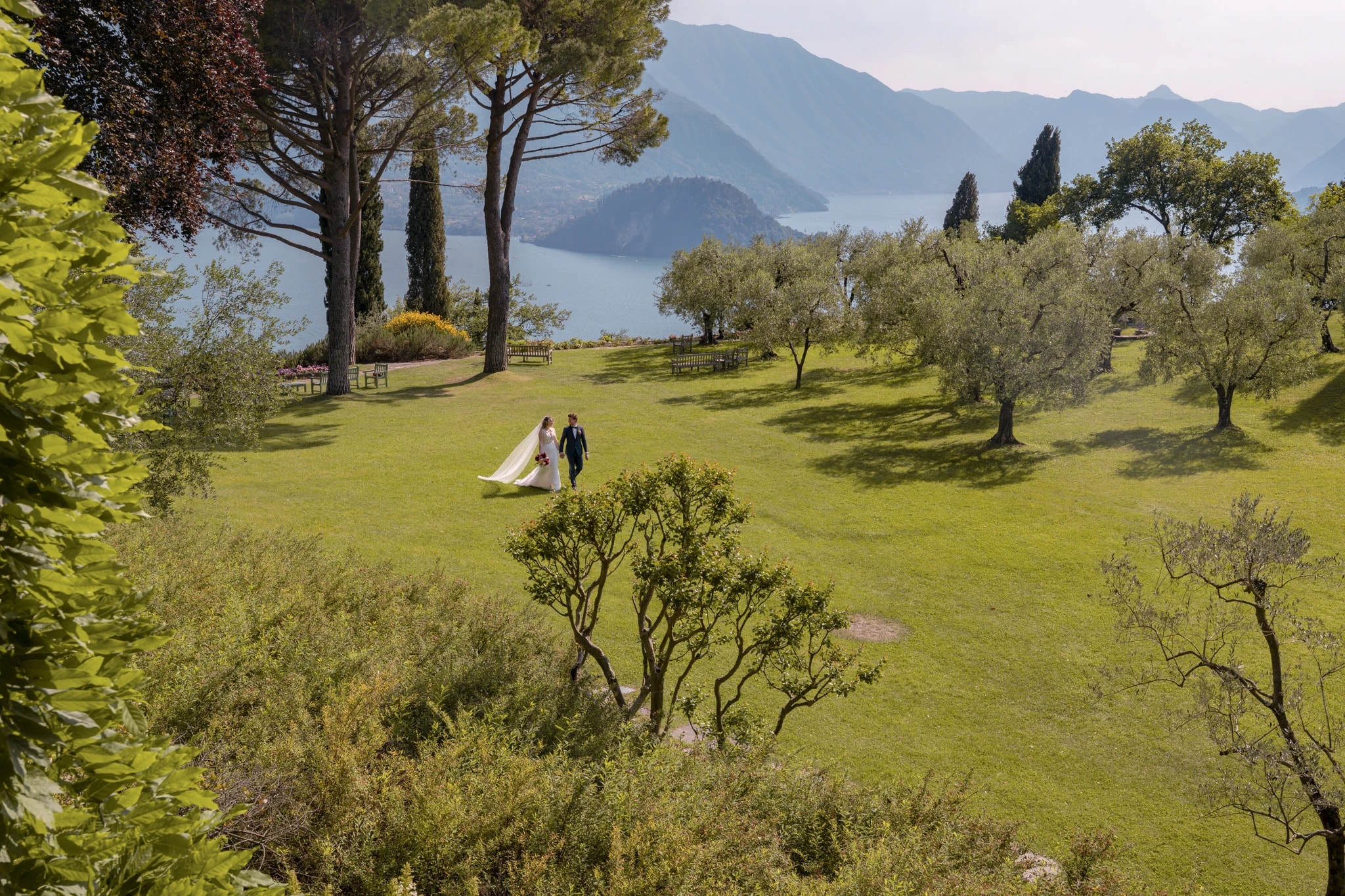 Brautpaar zwischen Olivenbäumen auf dem Gelände des Castello di Vezio bei einer Hochzeit am Comer See