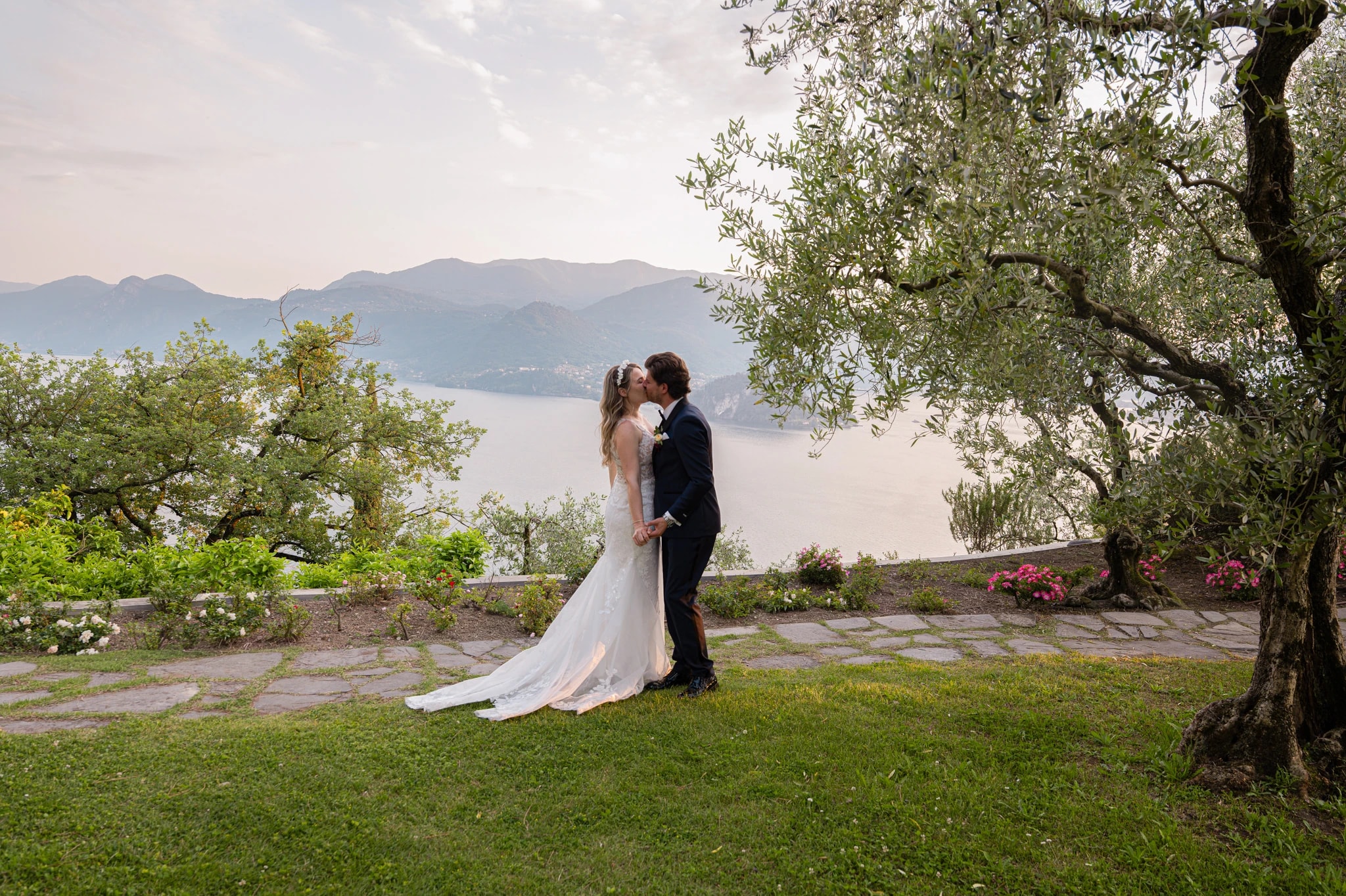 Küssendes Brautpaar mit Blick auf den Comer See und die Berge bei seiner Hochzeit im Castello di Vezio