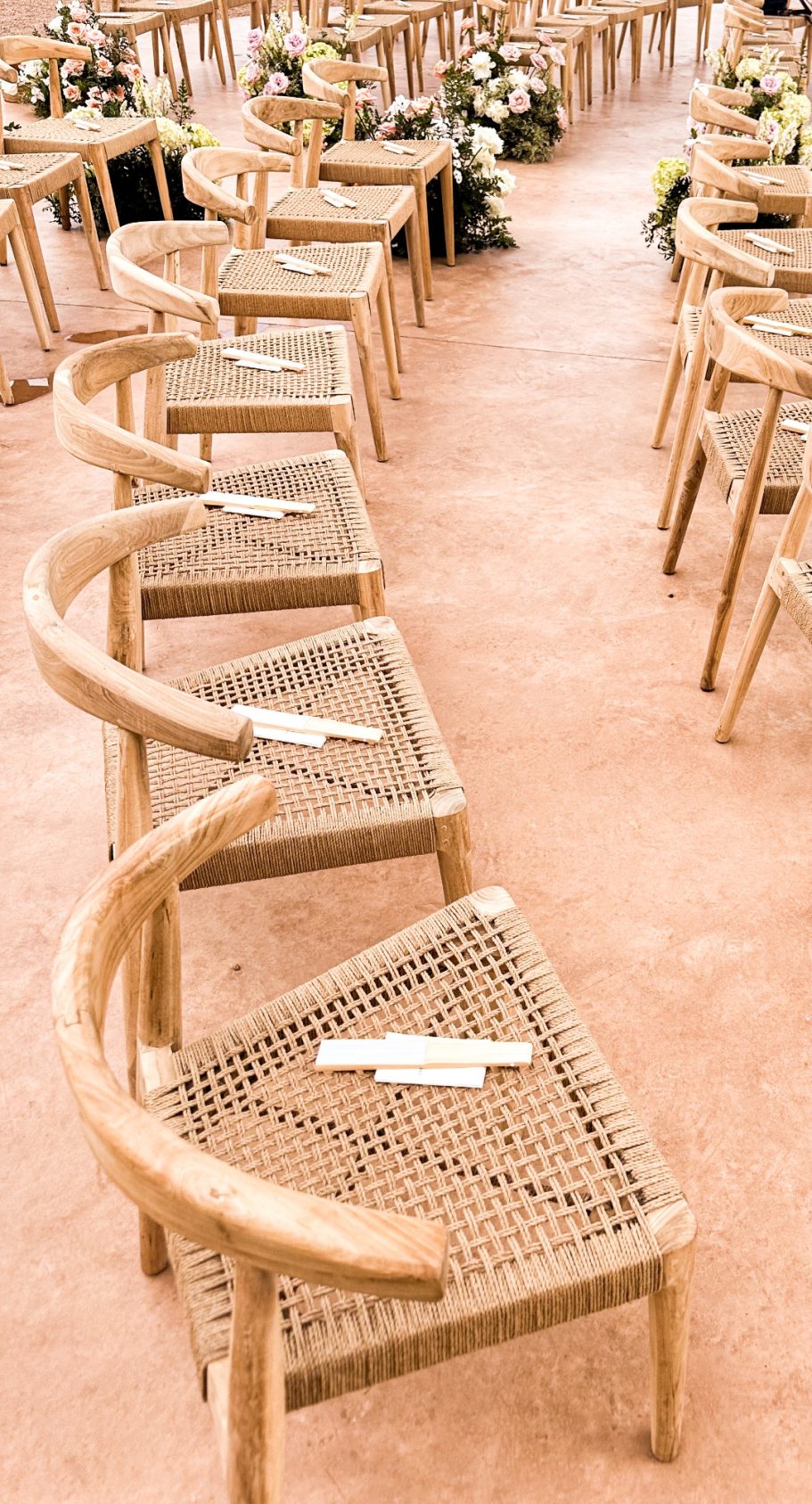 Elegante Stuhlreihen mit natürlicher Floristik – Hochzeitslocation auf Mallorca bereit für die freie Trauung

